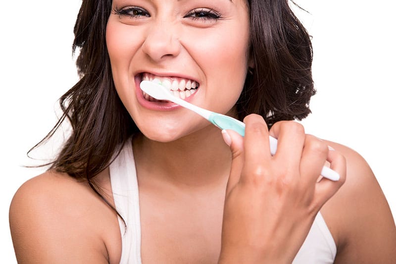 Beautiful Woman Brushing her Teeth— Dentist in Palm Beach, QLD