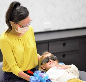 Dr Rhea with a child in the dentists chair during children's dentistry services
