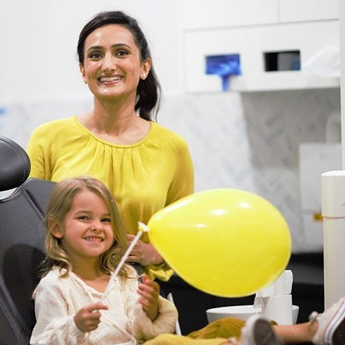 Dentist with Child Holding a Balloon — Dentist in Palm Beach, QLD