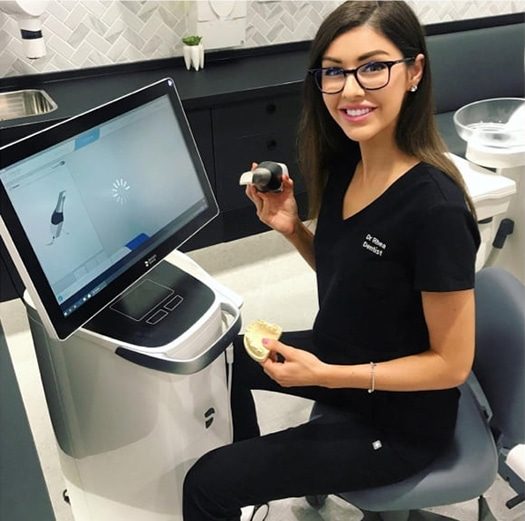A Beautiful Dentist Sitting in Front of the Computer — Dentist in Palm Beach, QLD